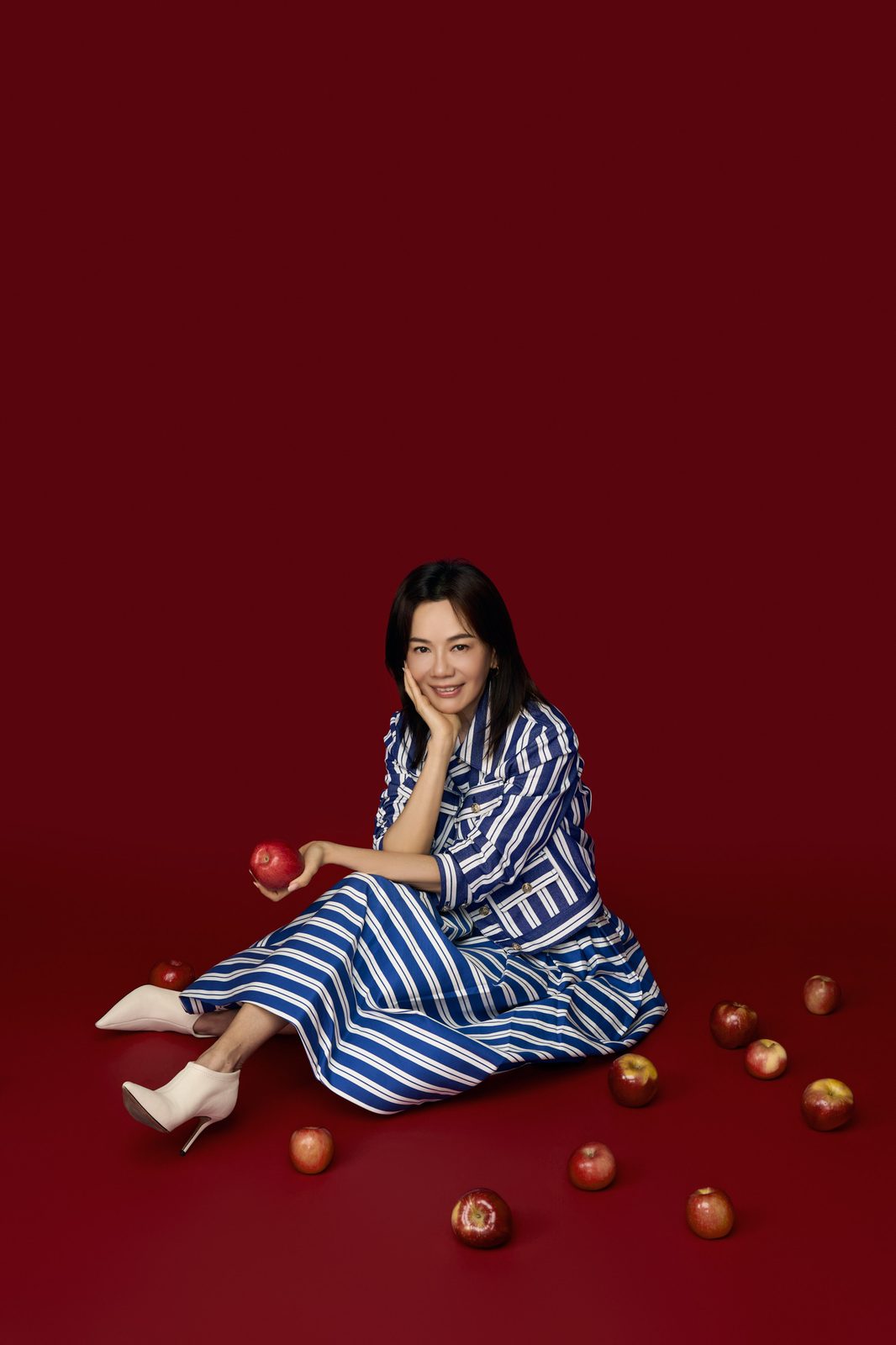 Rose Tsou seated, surrounded by apples